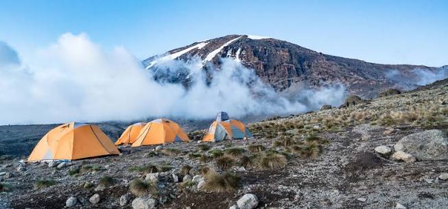 High-altitude camp on the Machame Route with Kilimanjaro peak above the clouds