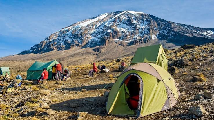 Marangu Route base camp with tents beneath the snow-capped summit of Kilimanjaro